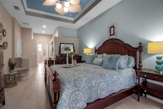 bedroom with a raised ceiling and ceiling fan