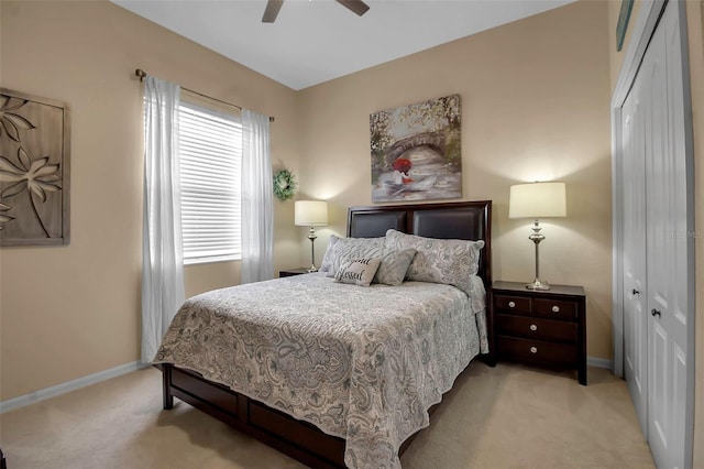 carpeted bedroom featuring ceiling fan and a closet