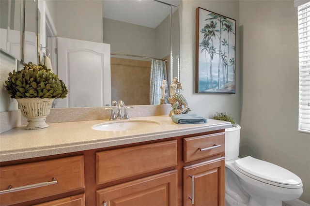 bathroom featuring vanity, curtained shower, and toilet