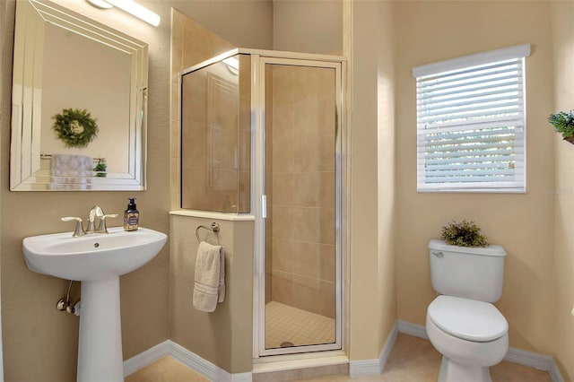 bathroom with sink, a shower with door, and toilet