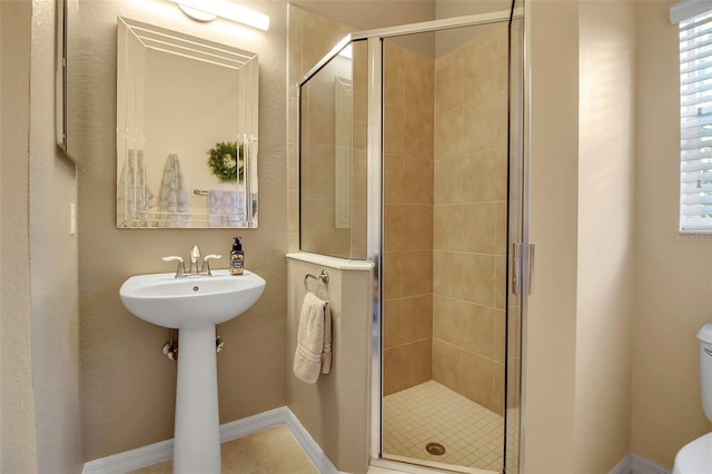 bathroom featuring an enclosed shower, toilet, and a wealth of natural light