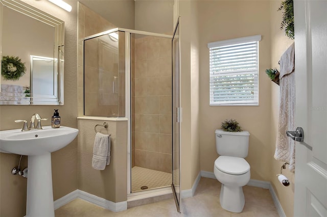 bathroom featuring sink, a shower with shower door, toilet, and tile patterned flooring