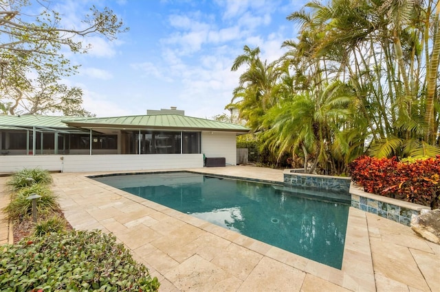 view of swimming pool featuring a patio and a sunroom