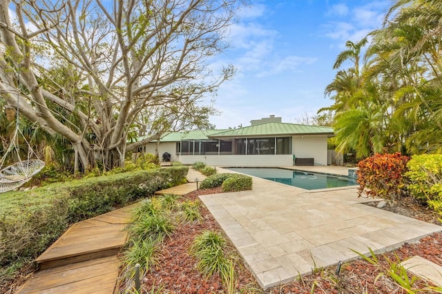 view of pool with a sunroom and a patio