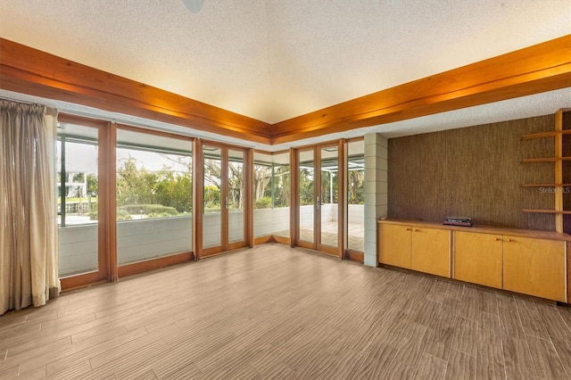 unfurnished sunroom with beam ceiling