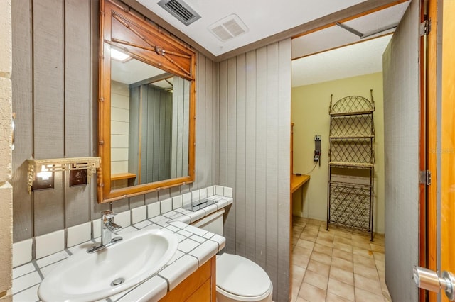 bathroom featuring tile patterned floors, vanity, and toilet