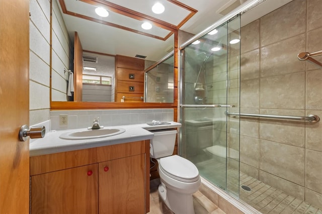 bathroom featuring vanity, toilet, a shower with door, and tile walls