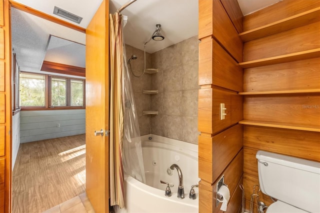 bathroom with toilet, shower / tub combo, tile patterned floors, and wood walls