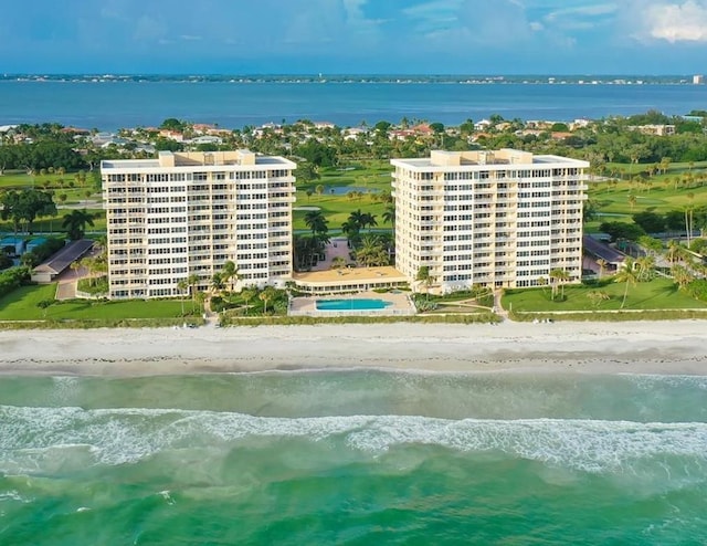 drone / aerial view featuring a water view and a beach view