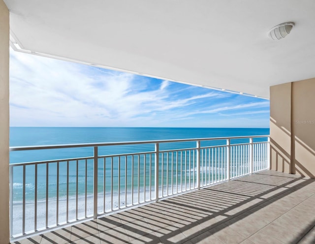 balcony featuring a beach view and a water view