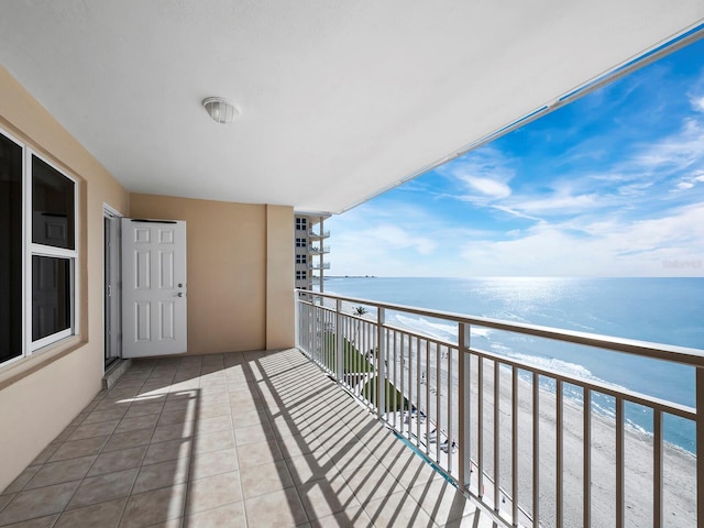 balcony with a water view and a view of the beach