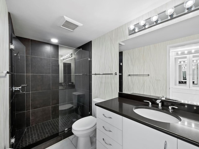 bathroom with tile patterned floors, vanity, an enclosed shower, and toilet