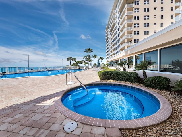 view of pool featuring a patio and a hot tub