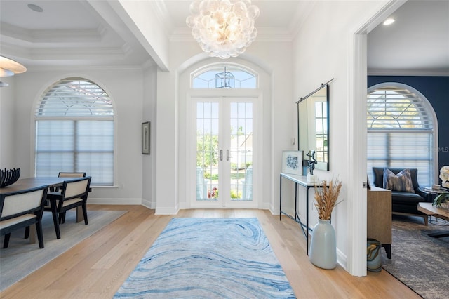 entryway featuring a wealth of natural light, light hardwood / wood-style flooring, and ornamental molding