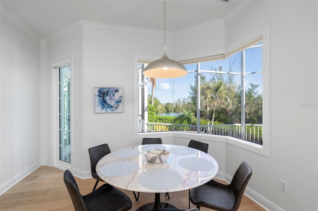 dining space with ornamental molding and light wood-type flooring