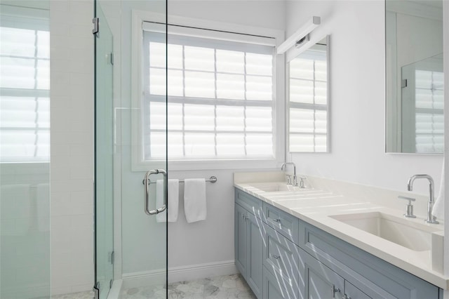 bathroom featuring vanity, a shower with door, and a wealth of natural light