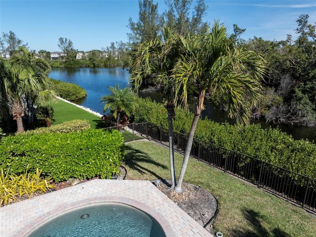 view of pool with a lawn and a water view