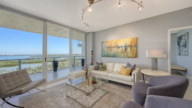 tiled living room with expansive windows and a water view