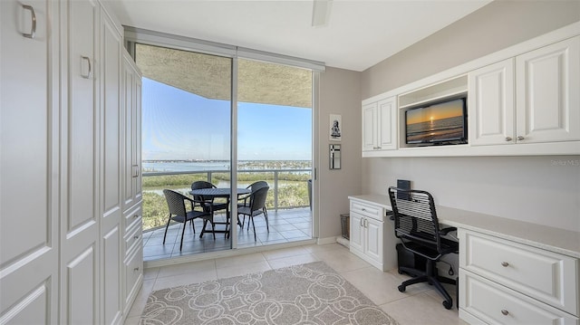 tiled home office featuring a water view and expansive windows