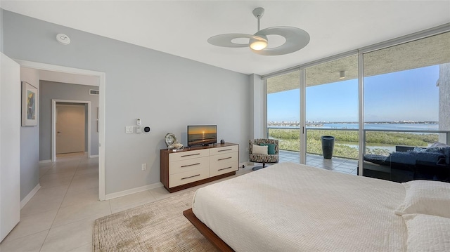 bedroom featuring ceiling fan, light tile patterned floors, access to exterior, and floor to ceiling windows