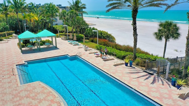 view of pool featuring a beach view, a gazebo, and a water view