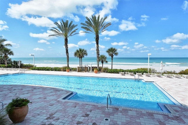 view of pool with a water view and a patio