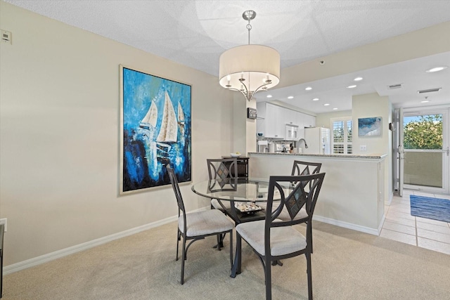 carpeted dining space featuring sink and a chandelier