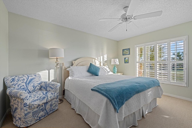 carpeted bedroom featuring a textured ceiling and ceiling fan