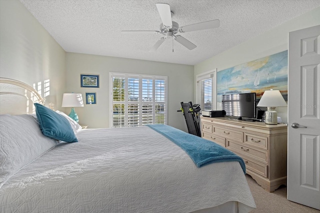 carpeted bedroom with a textured ceiling and ceiling fan