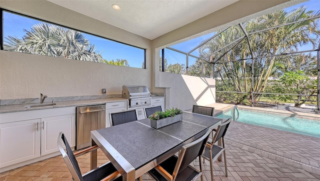 view of patio / terrace featuring area for grilling, sink, glass enclosure, and grilling area