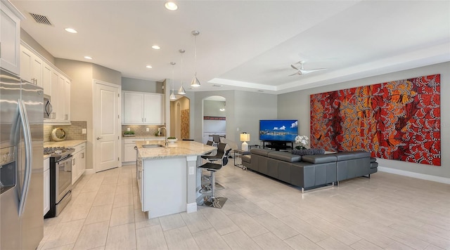 kitchen featuring pendant lighting, sink, an island with sink, white cabinetry, and stainless steel appliances