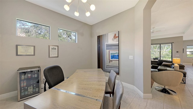 dining space featuring ceiling fan with notable chandelier