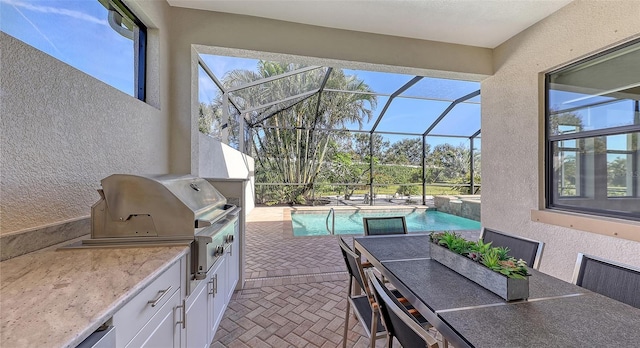 view of patio / terrace featuring grilling area, a lanai, and exterior kitchen