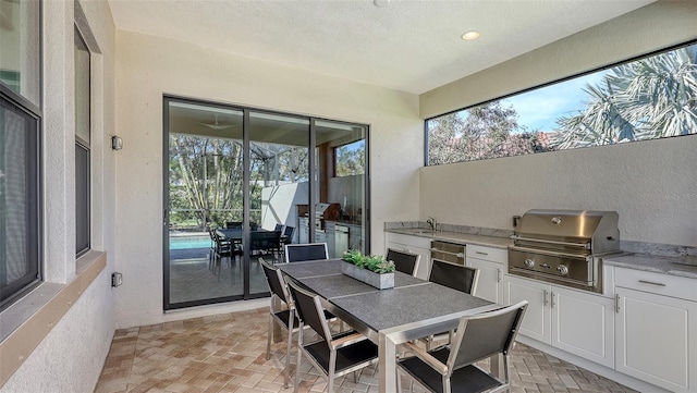 view of patio with a grill, sink, and area for grilling