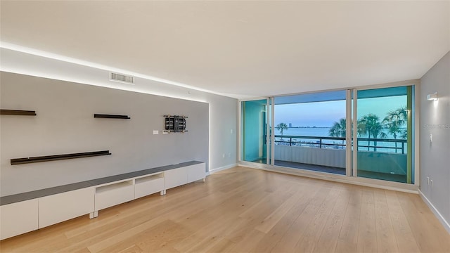 unfurnished living room featuring light hardwood / wood-style flooring and floor to ceiling windows