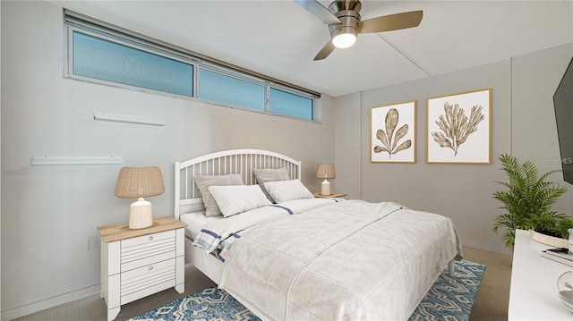 bedroom featuring ceiling fan and dark carpet