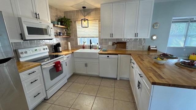 kitchen with sink, hanging light fixtures, wooden counters, white appliances, and white cabinets