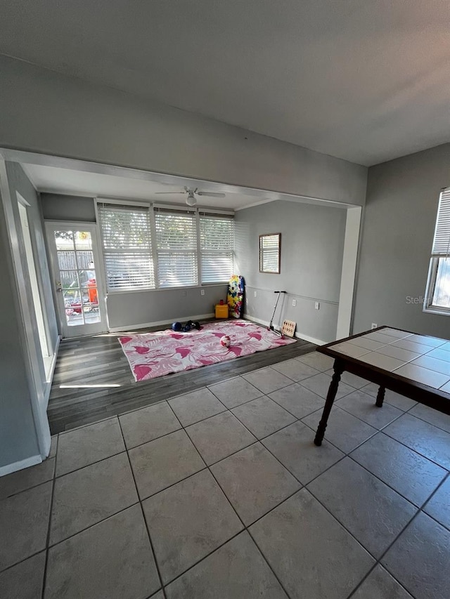 unfurnished living room featuring ceiling fan and light tile patterned floors