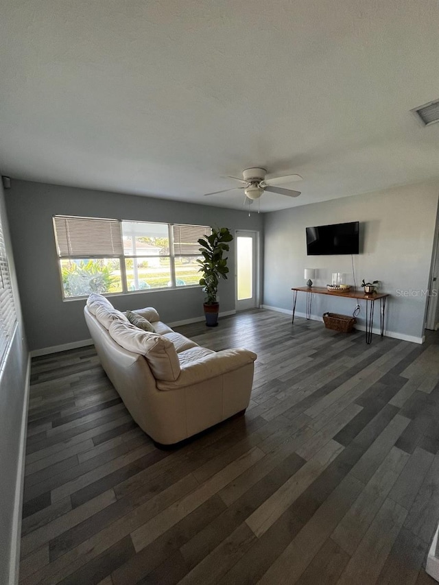 living room featuring ceiling fan and dark wood-type flooring