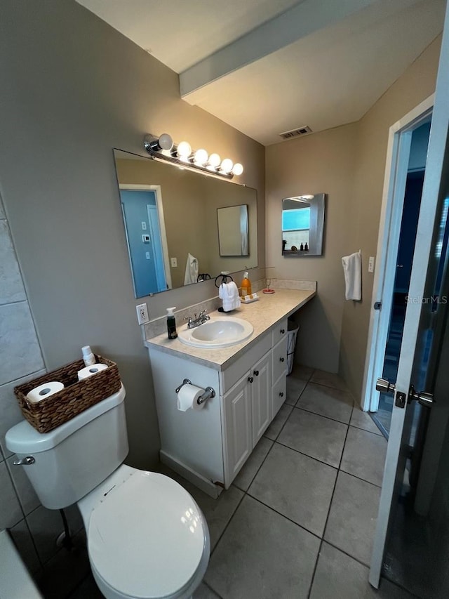 bathroom featuring tile patterned flooring, vanity, and toilet