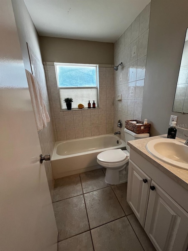 full bathroom featuring tile patterned flooring, toilet, vanity, and tiled shower / bath