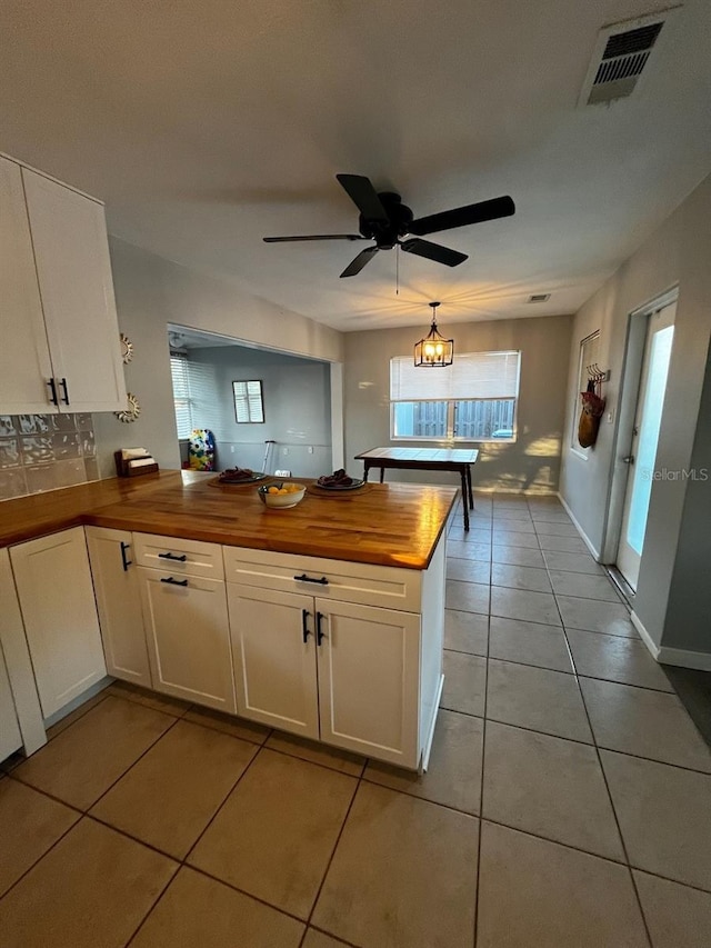 kitchen with white cabinetry, light tile patterned floors, and wooden counters