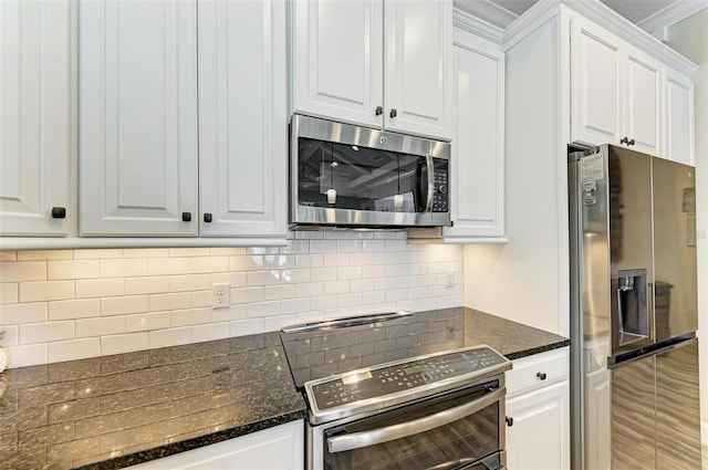 kitchen featuring tasteful backsplash, dark stone countertops, white cabinets, and appliances with stainless steel finishes