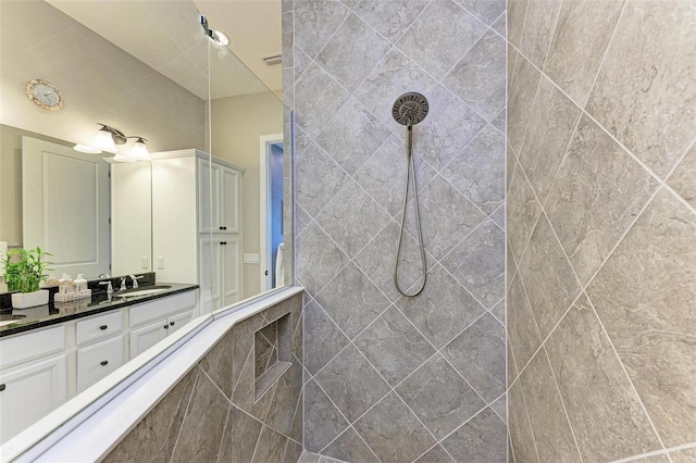 bathroom featuring vanity and tiled shower