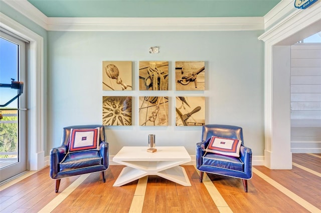 living area featuring hardwood / wood-style flooring and ornamental molding