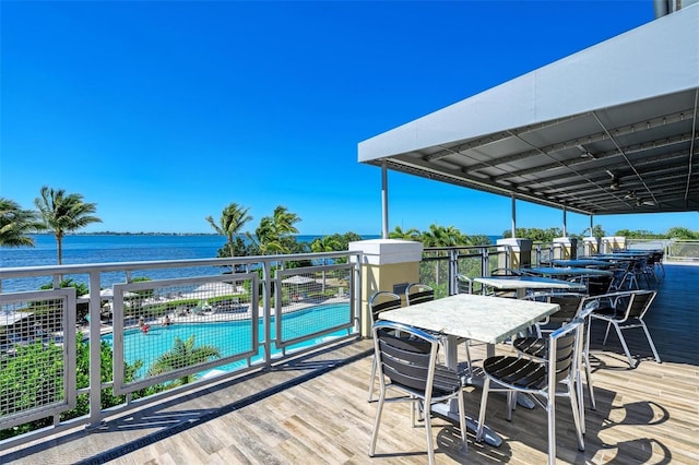 wooden terrace featuring a community pool and a water view