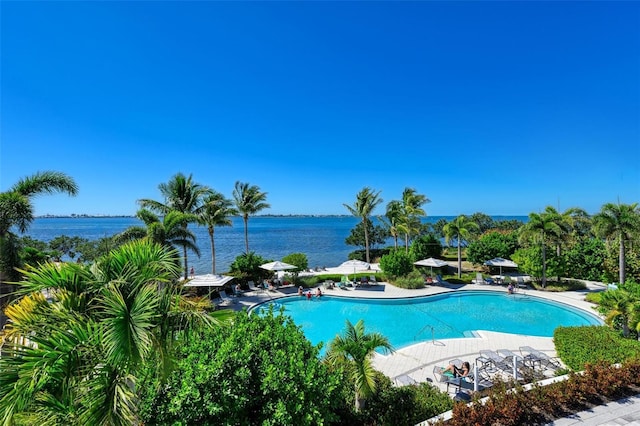 view of swimming pool with a water view and a patio