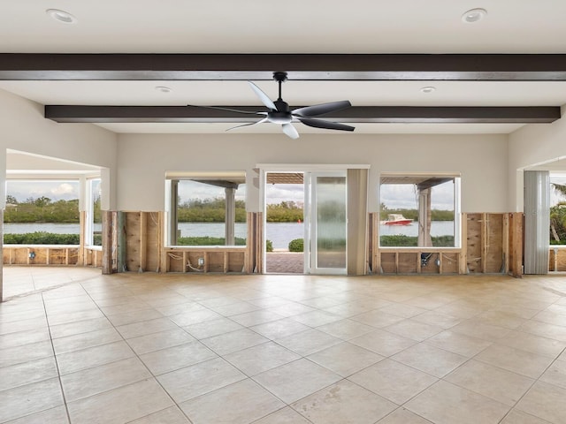 empty room with light tile patterned floors, a water view, and ceiling fan