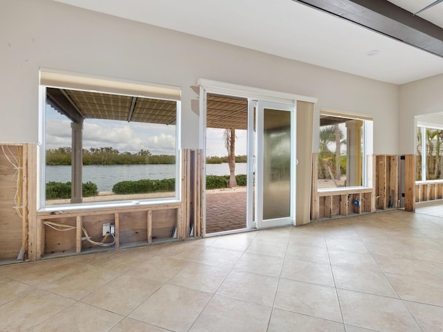 tiled empty room featuring a water view