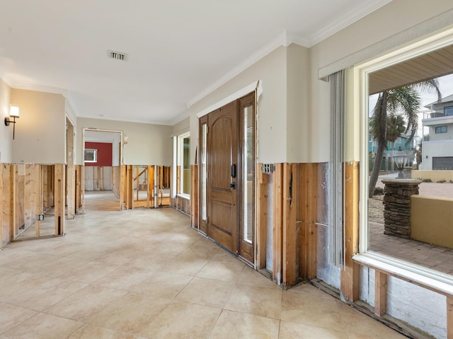 hall featuring ornamental molding and light tile patterned floors